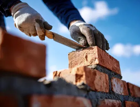 Mason laying brick for an outdoor fireplace near Lake Norman